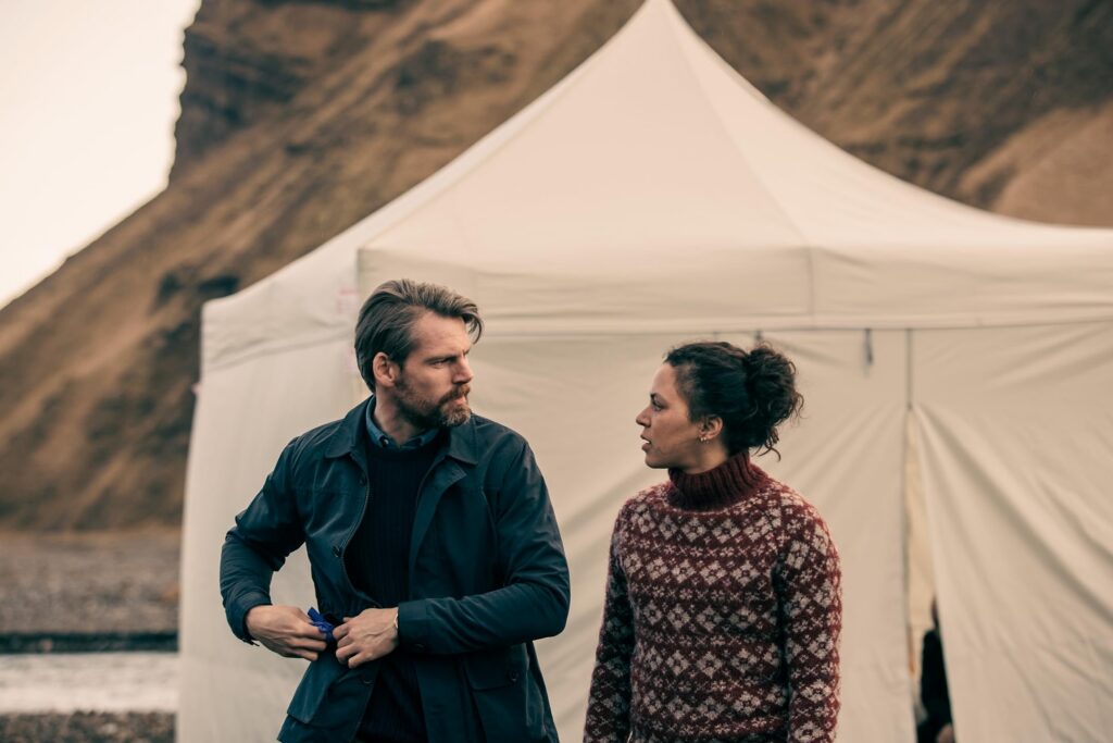 Beeld uit Black Sands: twee mensen bij een tent aan de kust