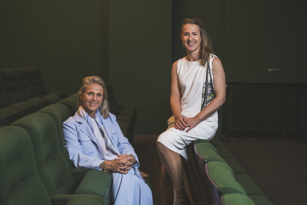 Twee toeschouwers in een bioscoopzaal met groene zetels